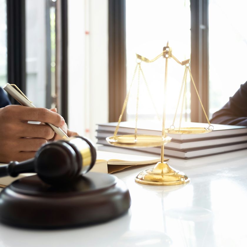 Détail sobre de la balance de la justice, en bronze, sur fond neutre.